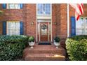 Inviting front entrance featuring brick steps, potted plants, and a wreath on the wood door at 2212 Austin Lake Se Dr, Smyrna, GA 30082