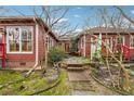 Exterior of the red house with brick walkway and a rustic garden trellis at 698 Bellemeade Nw Ave, Atlanta, GA 30318