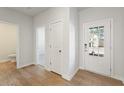 Inviting entryway showcasing wood-look flooring, a white front door with glass panes, and access to other rooms at 4155 Viola Pl, Atlanta, GA 30349