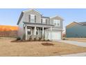 Charming two-story home with gray siding, black shutters, covered porch, and a spacious two-car garage at 4163 Viola Pl, Atlanta, GA 30349