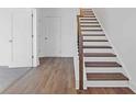 Staircase featuring durable laminate flooring on the steps and a wooden railing at 482 Hammons Way, Atlanta, GA 30315