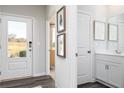 Bright foyer view to front door and glimpse of powder room with modern fixtures and decor at 610 Belshire Dr, Acworth, GA 30102