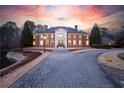 Striking front exterior view of brick home with manicured lawn and sunset sky at 4615 Northside Dr, Atlanta, GA 30327