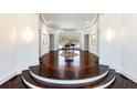 Open foyer with curved stairs, hardwood floors, bay window, and decorative lighting fixtures at 4615 Northside Dr, Atlanta, GA 30327
