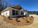 Landscaped side yard featuring newly planted bushes, a brick facade, and dark window shutters at 5311 Tuscany Drive, Douglasville, GA 30135