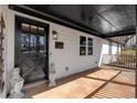 Spacious covered front porch featuring a dark-stained wood door with glass panes and vintage sconce light at 360 Chimney Ct, Fairburn, GA 30213