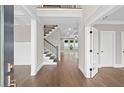 View of the foyer with hardwood floors, a staircase, and an open floor plan at 3790 Chattahoochee (Lot 33) Rd, Cumming, GA 30041