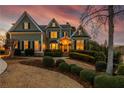 Inviting two-story home featuring warm exterior lighting, landscaped yard, and a beautiful sunset backdrop at 3963 Hazelhurst Lake Dr, Marietta, GA 30066