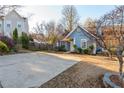 View of cozy blue home showcasing a large driveway and well-maintained front yard at 4162 Lake Mist Nw Dr, Kennesaw, GA 30144