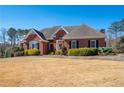 Attractive brick home with a lush, green lawn and trimmed shrubbery under a bright blue sky at 811 Weeping Willow Dr, Powder Springs, GA 30127