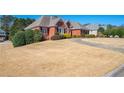 All-brick house on a manicured corner lot with green shrubbery accents under a clear sky at 811 Weeping Willow Dr, Powder Springs, GA 30127