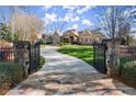 Elegant gated entrance with stone pillars and lush landscaping leading to a beautiful home at 3128 Lower Roswell Rd, Marietta, GA 30068