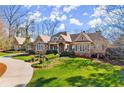 Beautifully landscaped front yard leading to a stately home with stone and neutral siding at 3128 Lower Roswell Rd, Marietta, GA 30068