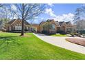 Expansive front lawn leading to an elegant home with a porte-cochere and stone accents at 3128 Lower Roswell Rd, Marietta, GA 30068