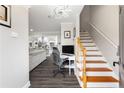 Welcoming entryway with hardwood stairs, gray walls, and an open floorplan with a kitchen beyond at 1445 Wheatfield Dr, Lawrenceville, GA 30043