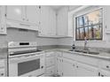 Bright kitchen features stainless appliances, stone countertops, ample white cabinetry, and a window view at 2571 Hamill Dr, Buford, GA 30519