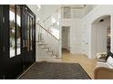 Bright foyer with hardwood floors, staircase, and wainscoting at 1605 Ridge Haven Run, Alpharetta, GA 30022