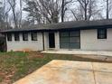 Ranch style home with white painted brick and dark trim and new driveway at 3490 Primrose Pl, Decatur, GA 30032