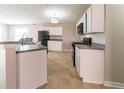 Functional kitchen featuring white cabinets, black appliances, and plenty of counter space at 493 Townsend Bnd, Stockbridge, GA 30281
