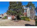 A brick home featuring lush landscaping,dormers, a well-manicured lawn, and mature trees creating a peaceful outdoor space at 1011 Buckhorn Bnd, Locust Grove, GA 30248