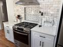 Modern kitchen with stainless steel appliances, white cabinetry, and subway tile backsplash at 1575 Montreat Pl, Atlanta, GA 30311
