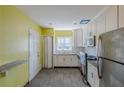 Bright kitchen featuring white cabinets, gray tile floors, stainless steel appliances and yellow walls at 3119 Bellgreen Way, Decatur, GA 30032