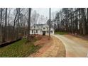 Two-story home with dormer windows surrounded by trees and a long concrete driveway at 255 Olde Oak Dr, Jonesboro, GA 30238