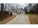 Two-story home with dormer windows, a two-car garage and a long concrete driveway at 255 Olde Oak Dr, Jonesboro, GA 30238