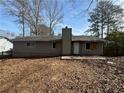 Exterior rear view of home featuring a chimney, door, and windows at 424 Independence Dr, Jonesboro, GA 30238