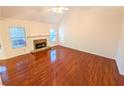Cozy living room with a stone fireplace and hardwood flooring at 6025 Ashbury Ln, Cumming, GA 30028