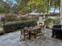Private backyard patio with stone fireplace, dining set, and grill, perfect for entertaining at 121 17Th Ne St, Atlanta, GA 30309