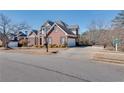 Stately brick home featuring a side-entry garage, ample parking, and mature trees at 1279 Saxony Se Dr, Conyers, GA 30013