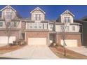 Inviting townhomes with brick facades, garages, and coordinated exterior finishes, all on a sunny day at 1935 Manor Pointe Dr, Cumming, GA 30041