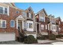 Charming townhome with brick facade, bay window, a one car garage, and manicured landscaping at 1286 Creekside Se Ter, Smyrna, GA 30082