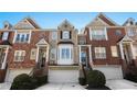 Desirable brick townhome with bay window, one car garage, front door wreath, and manicured bushes at 1286 Creekside Se Ter, Smyrna, GA 30082