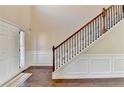 View of the home's staircase with decorative iron spindles, carpeted steps, and wood floors at 1465 Forest Brook Trl, Cumming, GA 30041