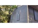 Blue home with boarded windows and wood siding, showcasing the property's exterior and renovation needs at 1775 Hadlock Sw St, Atlanta, GA 30311