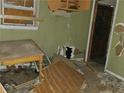 Damaged room with debris, missing drywall, and a boarded window needing extensive repair at 1775 Hadlock Sw St, Atlanta, GA 30311