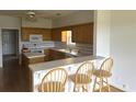 Bright kitchen featuring wooden cabinets, modern appliances, and a breakfast bar with chairs at 3220 Indian Shoals Rd, Dacula, GA 30019