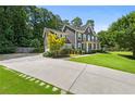 Elegant home featuring a long driveway, well-manicured lawn, and mature trees providing shade and privacy at 3460 Trow Creek Ln, Cumming, GA 30040