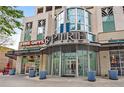 Commercial building entrance with glass doors, retail shops, and outdoor seating area at 860 Peachtree Ne St # 1502, Atlanta, GA 30308