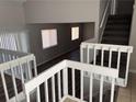 Foyer and staircase with white railings and newly installed laminate floors offer a glimpse into the home's updated interior at 4754 White Oak Path, Stone Mountain, GA 30088