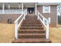 Welcoming front entrance with a brick staircase leading to a covered porch and decorative door at 6069 Shallow Wood Ln, Douglasville, GA 30135