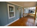 The home's inviting front porch features a wooden floor and a light blue exterior with white trim and a green front door at 127 Marona Ne St, Atlanta, GA 30307