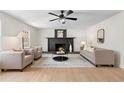 Inviting living room features a fireplace, plush seating, and a modern ceiling fan at 25 Queen Ct, Carrollton, GA 30116