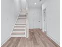 Inviting entryway with hardwood flooring and a staircase leading to the upper level and interior door at 484 Hammons Way, Atlanta, GA 30315