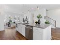 Open-concept kitchen with stainless steel appliances, island with seating, and hardwood flooring at 484 Hammons Way, Atlanta, GA 30315
