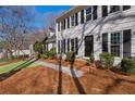 Home featuring a sidewalk leading to a covered entryway with black front door, and manicured yard at 4172 Westchester Ne Xing, Roswell, GA 30075