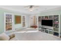 Open concept living room with large windows and a white built-in entertainment center at 4172 Westchester Ne Xing, Roswell, GA 30075