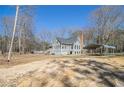 View of a quaint home with a large yard, shed, and metal carport under a clear blue sky at 459 Rabbit Run, Mcdonough, GA 30252